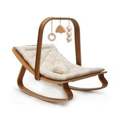 a wooden rocking chair with a white cushion on the seat and some balls hanging from it