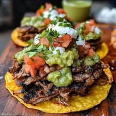 two tortillas topped with meat, guacamole and sour cream