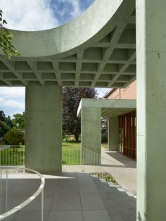 an empty walkway in front of a building with columns and railings on both sides