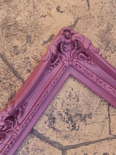 a pink frame sitting on top of a stone floor