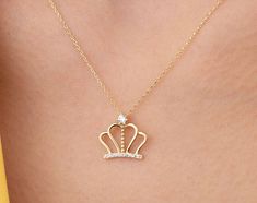 Our crown pendant necklace is 14k solid gold. Our crown pendant is decorated with zircon stones that look charming. When you consider it as a gift, it will make your loved ones happy on their birthday, mother's day, valentine's day, anniversaries, graduation, or women's day. It will be a perfect gift for your loved one that is the queen of your life. :) 🎁 If you want, you can add a gift note for your loved ones. It arrives in a special jewelry gift box. ✨ We respond to your questions happily. Y Elegant Cubic Zirconia Necklace For Birthday, Valentine's Day Elegant Crown Design Jewelry, Elegant Crown Design Necklace For Gift, Crown Design Jewelry For Valentine's Day Gift, Valentine's Day Gift Jewelry With Crown Design, Gold Cubic Zirconia Necklace For Birthday, Valentine's Day Crown Design Jewelry Gift, Elegant Crown Design Jewelry For Birthday, Elegant Crown Design Jewelry For Birthdays