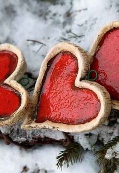 two heart shaped cookies sitting on top of snow covered ground