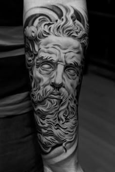 a man's arm with a black and grey tattoo on it, depicting the face of an old man