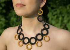 a close up of a woman wearing a necklace and earrings with circles on the front