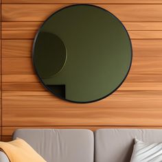 a round mirror on the wall above a couch