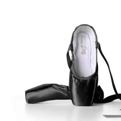 a pair of black ballet shoes sitting on top of a white floor next to a knife