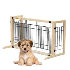 a puppy sitting in front of a dog gate