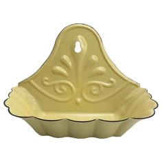 a yellow cupcake dish with an ornate design on the front and bottom, sitting in a white background