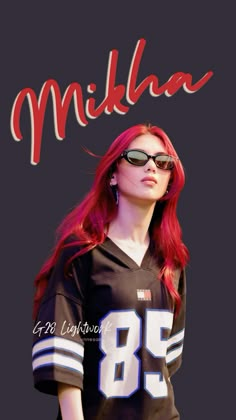 a woman with red hair and sunglasses is wearing a football jersey that reads, mikila