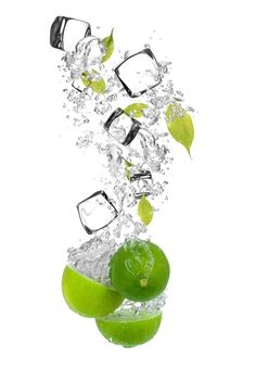 limes and ice cubes falling into the water with splashing on white background