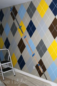 a ladder is sitting in front of a wall that has been painted with blue and yellow squares