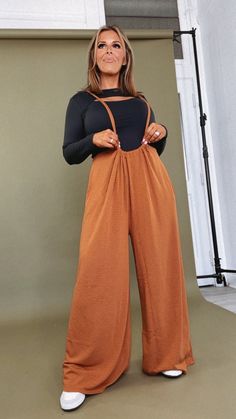 Just as effortless as it is adorable, our FLIRTY & FUN Head Over Heels Jumpsuit is featured in an oversized, slouchy fit with an adjustable tie-up back, and wide leg pant. A must-have staple for the Spring! Neckline: two straps into a jumpsuit design Fabric: 62% Polyester, 33% Rayon, 5% Spandex Details: Adjustable tie back, wide leg pant, ultra-comfortable design Made in the USA Fit: Oversized slouchy fit- adjustable tie backing Measurements: (*Fit varies due to oversized slouchy design. Tie back shoulder straps allow ample length adjustment) S-M-L Inseam 26" Rise 14 3/4" Waist to Hem (length) 40-41"  1XL-2XL-3XL Inseam 27" Rise 14 3/4" Waist to Hem (length) 41-42"  Model Specs: Karli + Emily are wearing a size small in photos. Syd is wearing the size 1xl.  How will this item fit you? Chec Jumpsuit Design, Suspender Jumpsuit, Festival Chic, Designer Jumpsuits, Everyday Chic, Comfortable Design, Head Over Heels, Wide Leg Pant, Design Fabric