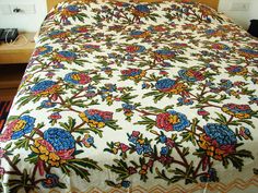 the bed is made with colorful flowers on it