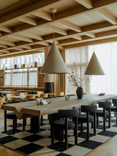 a dining room with black and white checkered flooring, two lamps hanging from the ceiling