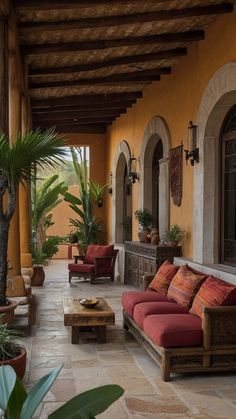 an outdoor patio with red couches and potted plants