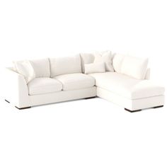 a white sectional couch with pillows on it's back and the seat folded down