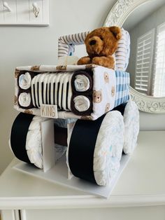 a teddy bear is sitting on top of a toy car made out of diapers