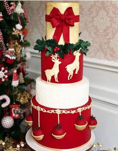 a three tiered christmas cake decorated with red and gold decorations