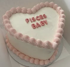 a heart shaped cake with the words pisgs baby written on it in pink icing