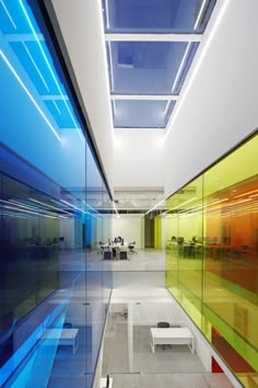 an empty room with glass walls and colorful lighting on the ceiling is seen in this image