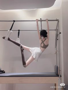 a woman hanging upside down on a pole with her legs up in the air,