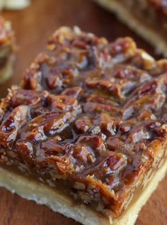 two pieces of pecan bar sitting on top of a wooden table