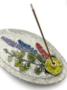 a glass plate with flowers and two sticks in it