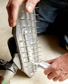 a man is working on a piece of metal with pliers in his hands,