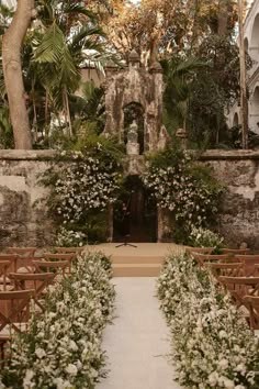 an outdoor ceremony with white flowers and greenery