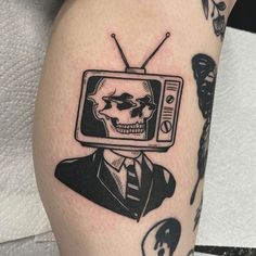 a skull wearing a suit and tie with a tv on it's head is shown