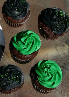 four cupcakes with green frosting and sprinkles