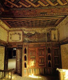 an old room with wooden doors and paintings on the walls