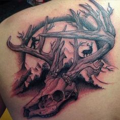 the back of a man's shoulder with an animal skull and antlers on it