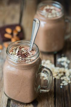 two jars filled with chocolate and oats on top of a wooden table