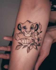 a woman's arm with a lion and flowers tattoo on the left side of her arm