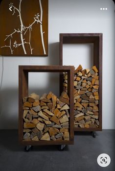 two pieces of wood stacked on top of each other in front of a wall mounted painting