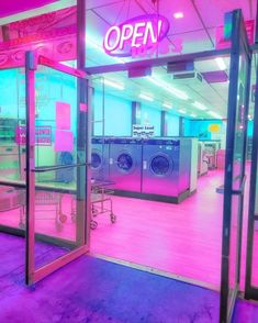 an open laundry room with washing machines and neon lights