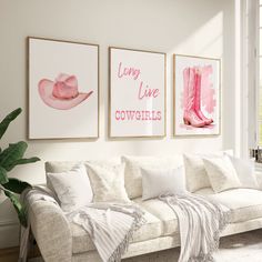 a living room filled with white furniture and paintings on the wall above it's couch