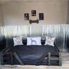 a bed made out of wooden pallets in a room with metal walls and wood flooring