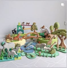 an assortment of wooden toy animals and trees