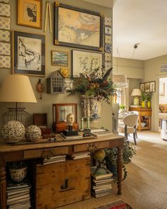 a living room filled with lots of furniture and pictures on the wall above it's desk