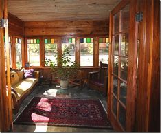 the sun shines through two windows into a room with wooden walls and flooring