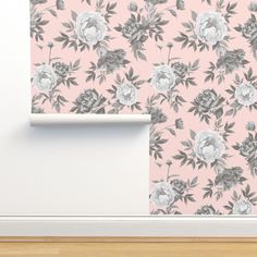 a pink wallpaper with grey and white flowers on it, next to a wooden floor