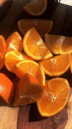 sliced oranges sitting on top of a wooden cutting board