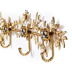 an ornately decorated gold coat rack on a white wall