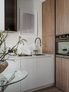 a kitchen with white cabinets and glass counter tops