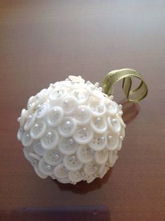 an ornament made to look like a ball with buttons on it sitting on a table