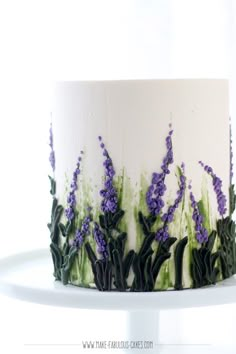 a white cake with purple flowers on it