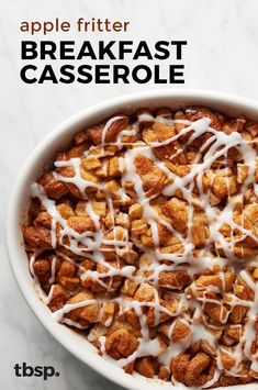 a breakfast casserole in a white bowl with icing drizzled on top