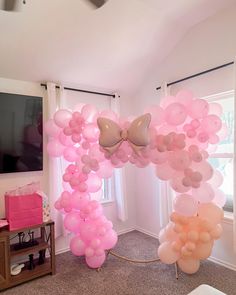 a room with balloons and bows hanging from the ceiling